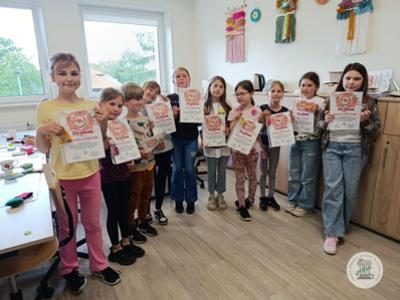 Dzieci prezentują dyplomy, czyli zajęcia podsumowujące zajęcia rękodzielnicze w Gminnym Ośrodku Kultury w Stawigudzie