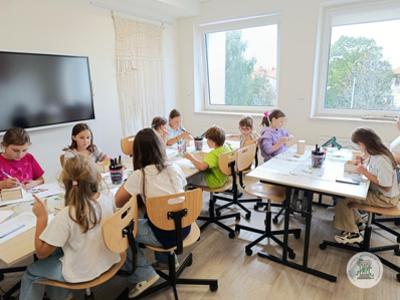 Dzieci podczas zajęć w pracowni rękodzielniczej. Dekorują pojemniki ze sklejki