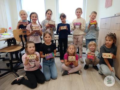 dzieci pokazują skrzynki z zajęć rękodzielniczych w Stawigudzie