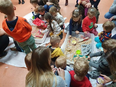 dzieci bawiące się ziarnami pszennymi w wielkich pojemnikach