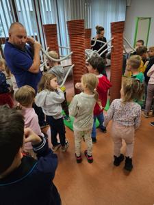 grupa dzieci stająca obok mężczyzny w niebieksiej koszulce