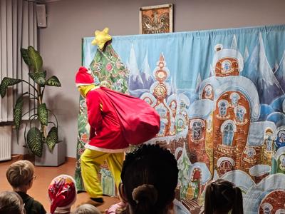 Grupa dzieci siedzących i oglądających przedstawienie