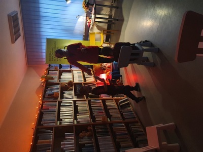 kobieta oraz dwójka dzieci w sali bibliotecznej, przyciemnione światło