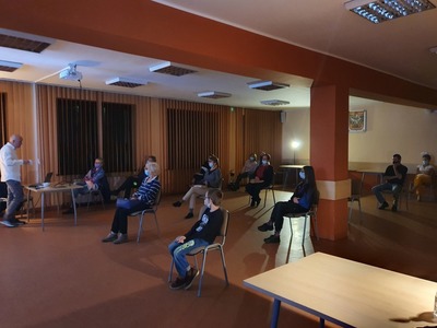Grupa ludzi siedząca na dużej sali