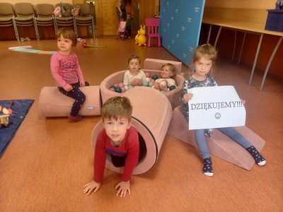 Dzieci bawiące się różowymi, pluszowymi zabawkami w kształcie figur geometrycznych