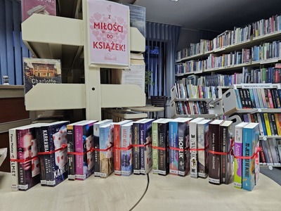 Na zdjęciu książki po dwie związane czerwoną wstążką i ustawione jedna obok drugiej. 