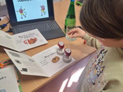 dziewczynka przystawiająca pieczątki w książce