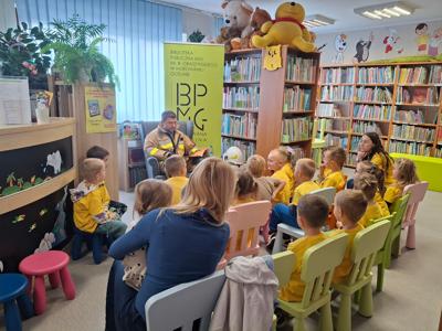 strażak czyta przedszkolakom w bibliotece