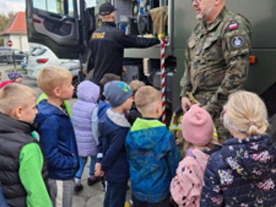 żołnierz pokazuje wóz dzieciom