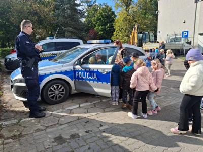 policjant pokazuje radiowóz dzieciom