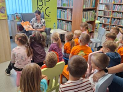 pielęgniarka czytająca przedszkolakom w bibliotece