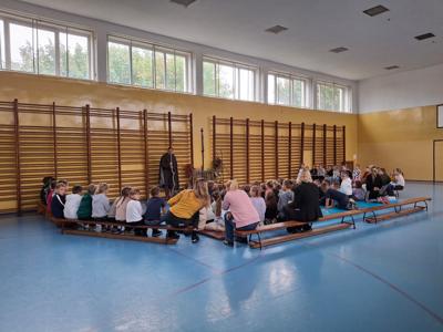 sala gimnastyczna, dzieci zgromadzone wokół mężczyzny przebranego za wędrowca