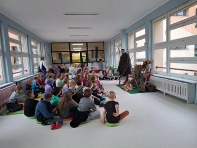 dziec izgromadzone wokół męzczyzny przebranego za pradawnego mężczyznę
