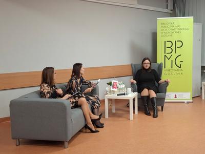 dwie kobiety siedzxą na kanapie, obok na fotelu siedzi kobieta