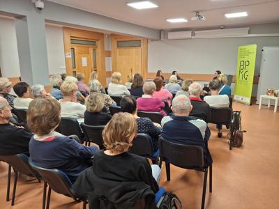 osoby dorosłe od tyłu siedzące na krzesłach