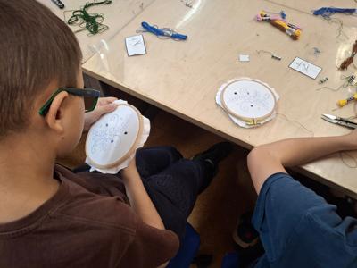 chłopiec trzymający tamborek i haftujący