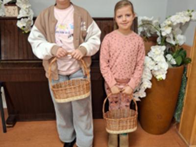 dwie dziewczynki trzymające koszyki wiklinowe