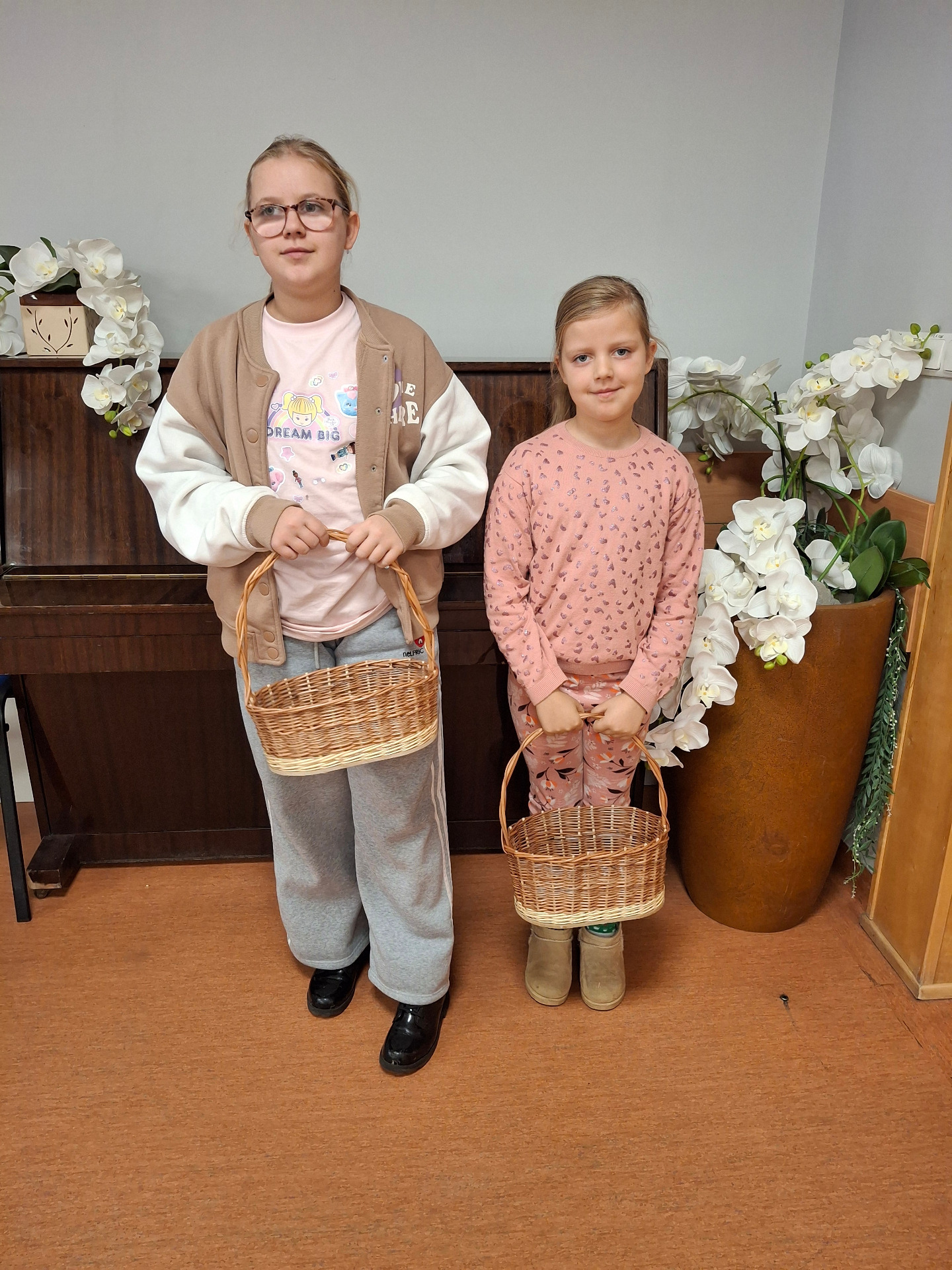 dwie dziewczynki trzymające koszyki wiklinowe