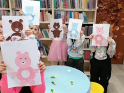 dzieci trzymające obrazki misiów