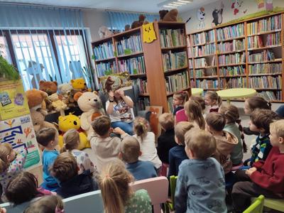 grupa dzieci siedząca w bibliotece