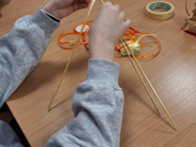 ręce dziecka wyplatającego słomkę