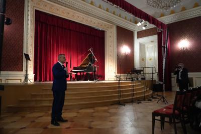 Mężczyzna z mikrofonem zapowiadający koncert.