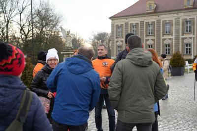 Grupa ludzi na tle Pałacu Książęcego w Żaganiu.