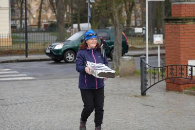 Kobieta idzie z paczką w rękach.