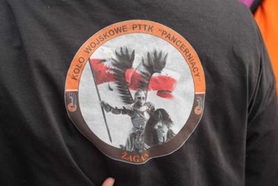 Nadruk na koszulce : "Koło Wojskowe PTTK "Pancerniacy"", w środku husarz na koniu trzymający flagę Polski.