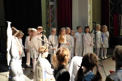 Grupa dziecięca na scenie - dwie dziewczynki przy mikrofonie.