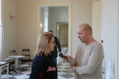 Pan z mikrofonem przeprowadza wywiad z kobietą.