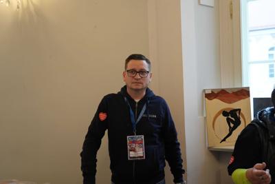 Pan - wolontariusz WOŚP. W tle obraz.