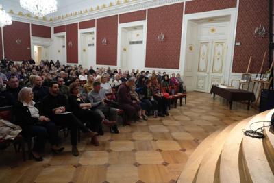 Publiczność siedzi przed sceną oglądając występy.