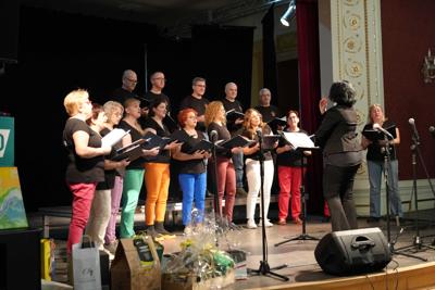 Grupa ludzi na scenie, występ chóru.