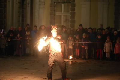 Jest ciemno, pan występuje z ogniem przed publicznością.