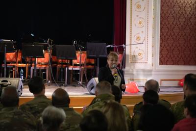 Pani z mikrofonem zapowiada występy, za nią scena.