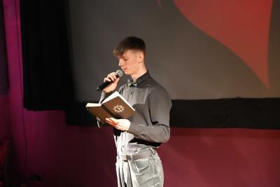 Chłopak czyta książkę do mikrofonu.