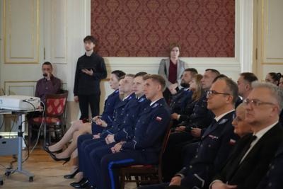 Na widowni siedzą policjanci.