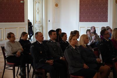 Policjanci siedzący na widowni.