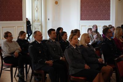 Policjanci siedzący na widowni.