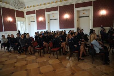 Policjanci siedzący na widowni.
