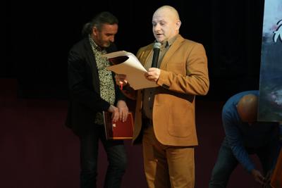 Pan z mikrofonem zapowiada występy na scenie.