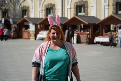Uśmiechnięta pani z króliczymi uszkami. W tle widać stoiska.