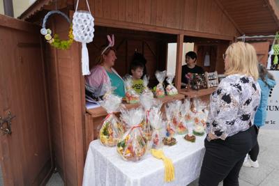 Ludzie wokół stoiska z barankami wielkanocnymi.