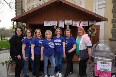 Grupa pań pozująca przy stoisku z jedzeniem. Mają koszulki z Koła Gospodyń Wiejskich w Starej Koperni.