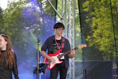 Chłopak gra na gitarze na scenie.