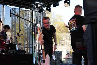 Chłopak odkłada gitarę na scenie.
