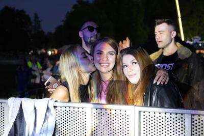 Dziewczyny pozują razem do zdjęcia przy barierkach pod sceną.