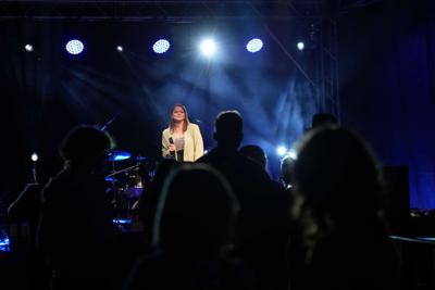 Grupa osób pod sceną podczas występu wokalistki.
