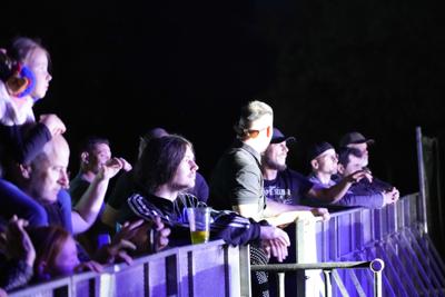 Grupa osób przy barierkach pod sceną.